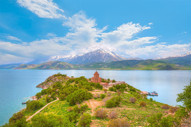 A building by a lake with a mountain in the background.